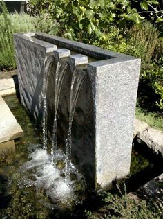 two water fountains in the middle of a garden