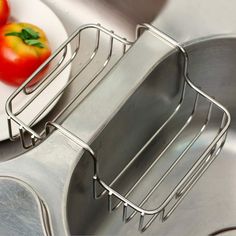 a metal sink with two pans and some tomatoes