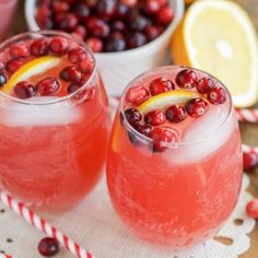 two glasses filled with cranberry lemonade and garnished with orange slices