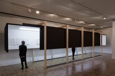 two people standing in front of three black screens