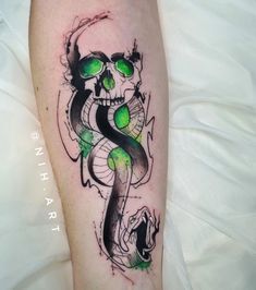 a skull and snake tattoo on the left arm, with green eyes in front of it