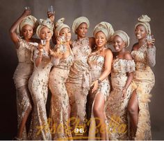 a group of women standing next to each other holding wine glasses and posing for the camera