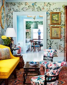 a living room filled with furniture and pictures on the wall next to an open door