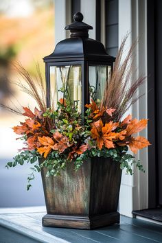 a lantern with some flowers in it sitting on a window sill next to a planter