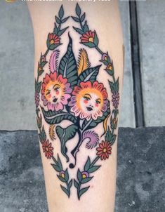 a woman's leg with flowers and leaves on it