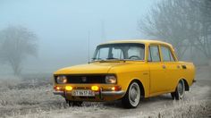 an old yellow car is parked in the fog