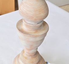 a wooden candle holder sitting on top of a white table