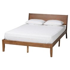 a wooden bed frame with white pillows on it