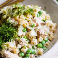 a white bowl filled with pasta and peas