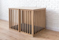 a wooden crate sitting on top of a hard wood floor next to a white brick wall