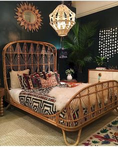 a rattan bed frame in a bedroom with black walls and patterned rugs on the floor