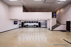 an empty garage with stairs and cabinets