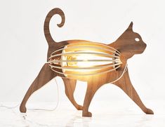 a wooden cat lamp with a light bulb on it's back and its tail curled up