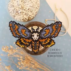 the beaded butterfly is sitting on top of a plate