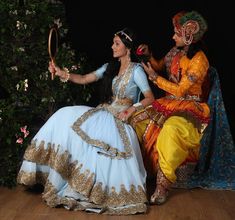 two people dressed in costume sitting on the ground