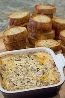 some bread sticks and a casserole dish on a wooden cutting board next to it