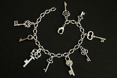 A collection of silver plated miniature key charms have been dispersed around a shimmering silver plated bracelet chain in this handmade charm bracelet. This skeleton key charm bracelet is then completed with a lobster clasp and a 1/2 inch of chain at the end for adjustable sizing. Charms in this bracelet include nine assorted skeleton key charms. ● Sizing ● To determine your bracelet size, do a snug measurement of your wrist's circumference, then add 1/2 an inch. 6 to 6.5 inches (15cm - 16.5cm) Handmade Silver Charm Bracelet, Silver Dangle Charm Bracelet, Unique Silver Dangle Charm Bracelet, Handmade Symbolic Silver Charm Bracelet, Symbolic Handmade Silver Charm Bracelet, Unique Silver Charm Bracelet With Lobster Clasp, Key Charm Bracelet, Unique Silver Nickel-free Charm Bracelet, Lock And Key Bracelet