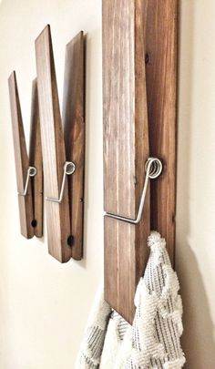 a coat rack with three hooks and two towels hanging from it's sides on a wall