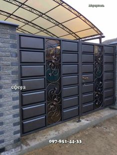 an iron gate that has been installed to the side of a brick building with a canopy over it