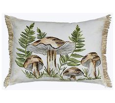 an embroidered pillow with mushrooms and ferns on it