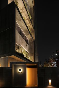 the entrance to an office building lit up at night