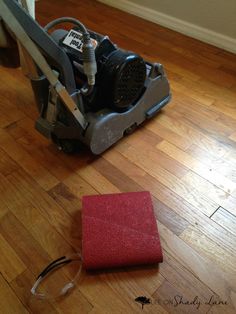 a red carpet cleaning machine sitting on top of a hard wood floor