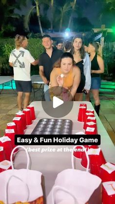 a group of people standing around a table with cups on it