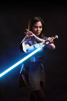 a woman holding a light saber in her hand