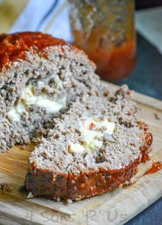 sliced meatloaf on a cutting board with sauce