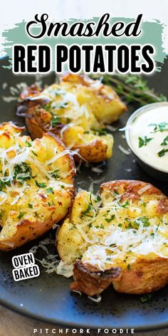 baked red potatoes with parmesan cheese and herbs on a plate next to dipping sauce