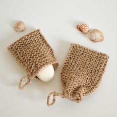 a knitted bag and some seashells on a white surface