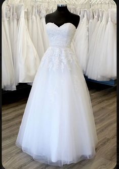 a white wedding dress on display in a store