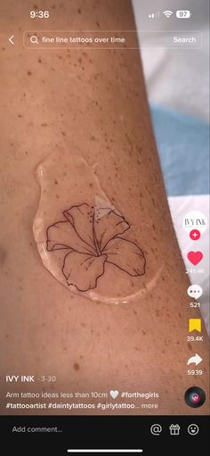 a tattoo on someone's arm that has a flower drawn on the back of it