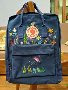 Welcome to my store and choose the perfect hand-embroidered fjallraven kanken backpack   Version & Size + Medium size: 38x27x13cm  + Big size: 42x32x13cm  - Product price includes: hand-embroidered fjallraven kanken backpack and design as shown in the picture - I can make fjallraven kanken backpack hand embroidery patterns according to your ideas - fjallraven kanken backpack will be hand embroidered with thread that won't fade when washed - fjallraven kanken backpack has a small front compartmen Kanken Backpack Embroidery, Embroidered Kanken, Backpack Kanken, Kanken Embroidery, Backpack Embroidery, Mochila Fjallraven Kanken, Colorful Jellyfish, Embroidered Backpack, Dog Memorial Gift