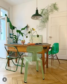 a dining room table with green chairs in front of it