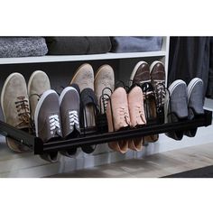 several pairs of shoes are lined up on a shelf