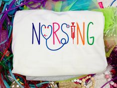 a white bag with the word nursing on it surrounded by beads and other items that include bracelets