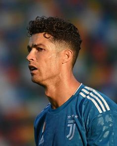 a close up of a soccer player wearing a blue uniform and looking off to the side