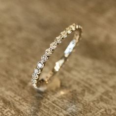 a white gold wedding band with diamonds on the inside and outside, sitting on a wooden surface