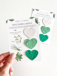 two green and white heart shaped magnets on top of a card next to each other