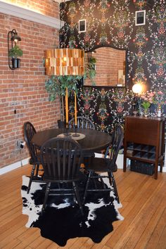 a dining room table with chairs and a cowhide rug