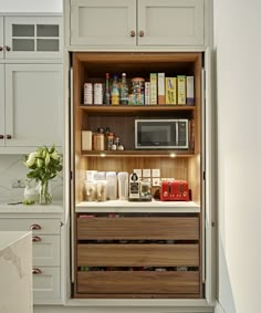 an open cabinet in the middle of a kitchen