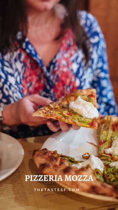 a woman is eating a slice of pizza