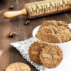 some cookies are sitting on a table next to a rolling pin and cookie cutters