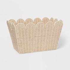 a wicker basket with scalloped edges on a white background for storage or display