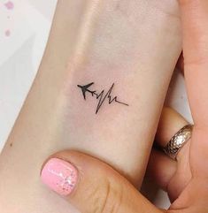 a woman's arm with a small heartbeat tattoo on the left side of her wrist