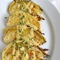 grilled artichokes on a white plate topped with gravy and garnish