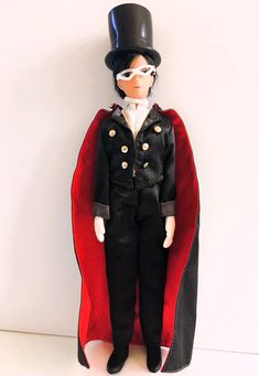 a toy doll wearing a top hat and cape