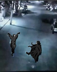 two people dressed in black are flying through the air with their hands up and one person is wearing a cape