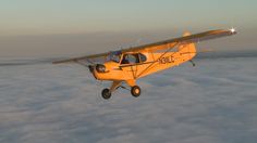 an airplane flying above the clouds at sunset